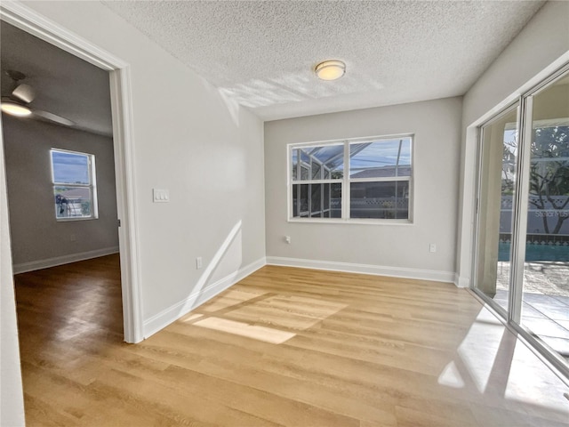 unfurnished dining area featuring hardwood / wood-style floors, a textured ceiling, and plenty of natural light