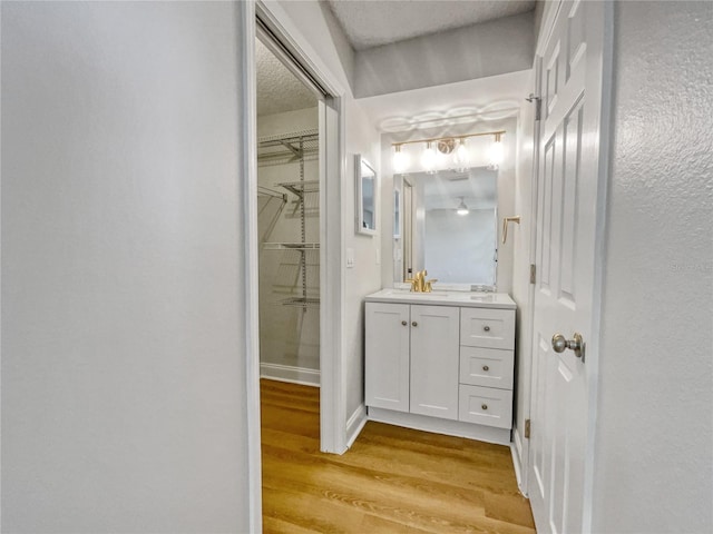 bathroom with hardwood / wood-style floors, vanity, and a textured ceiling