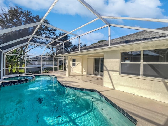 view of swimming pool featuring an in ground hot tub, glass enclosure, and a patio area