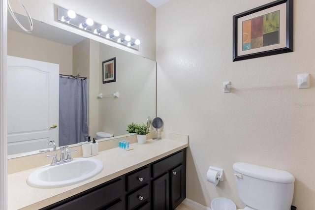 bathroom featuring a shower with shower curtain, vanity, and toilet