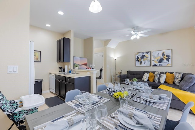 dining space with ceiling fan, light tile patterned floors, and sink