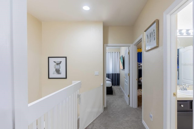 corridor with light colored carpet and sink