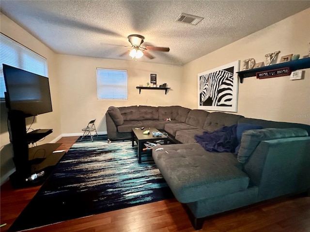 living room featuring ceiling fan, wood-type flooring, and a textured ceiling