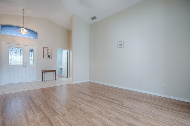 entryway with high vaulted ceiling and light wood-type flooring