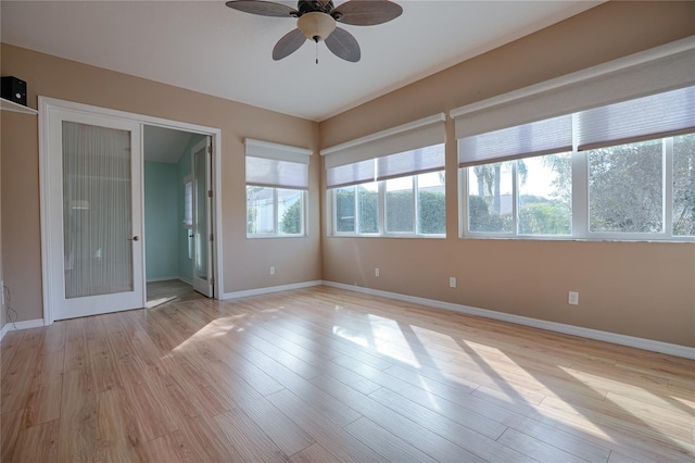 empty room with plenty of natural light, ceiling fan, and light hardwood / wood-style floors