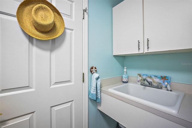 laundry area with cabinets and sink