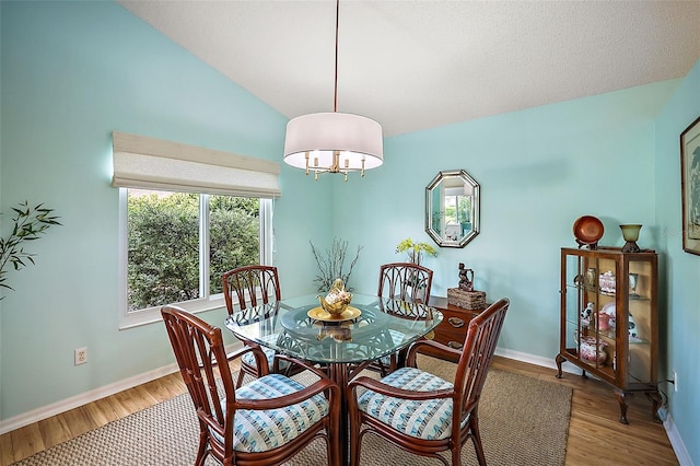 dining room featuring lofted ceiling and hardwood / wood-style floors