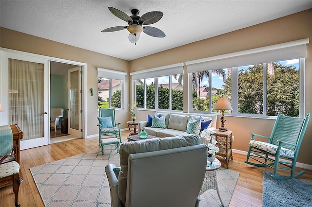 sunroom / solarium featuring plenty of natural light, french doors, and ceiling fan