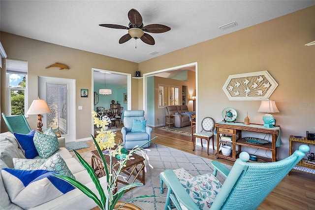 living room with ceiling fan and light hardwood / wood-style flooring