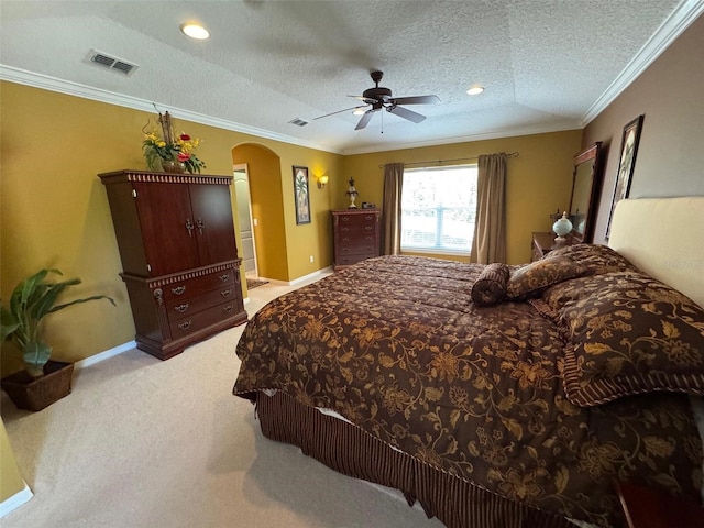 bedroom with arched walkways, visible vents, crown molding, and a textured ceiling