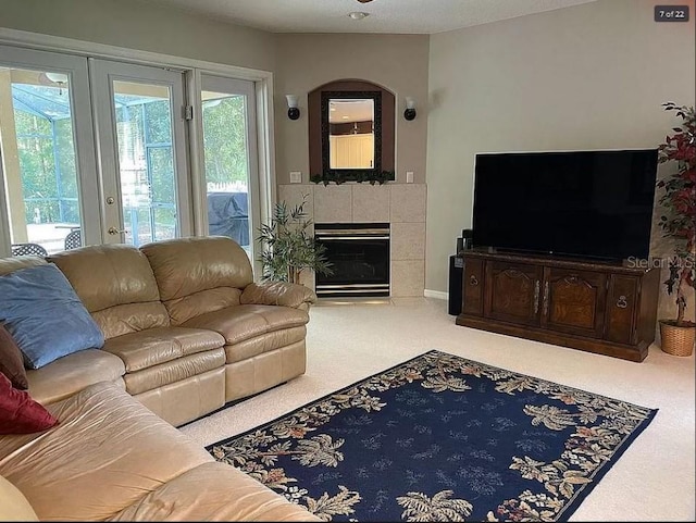 carpeted living area with a tiled fireplace