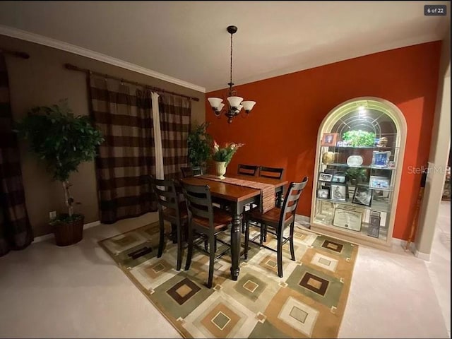 dining space featuring an inviting chandelier, baseboards, and crown molding