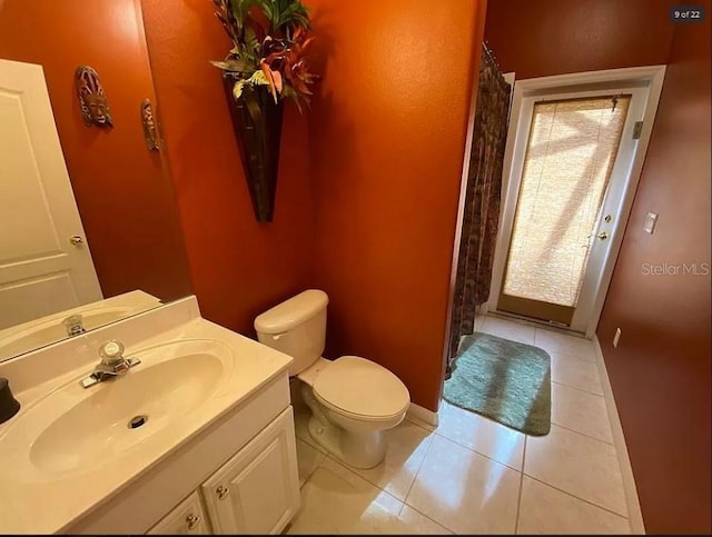 bathroom featuring tile patterned flooring, toilet, a shower with shower curtain, vanity, and baseboards