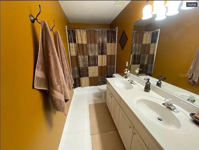 bathroom featuring double vanity, toilet, tile patterned flooring, a textured ceiling, and a sink