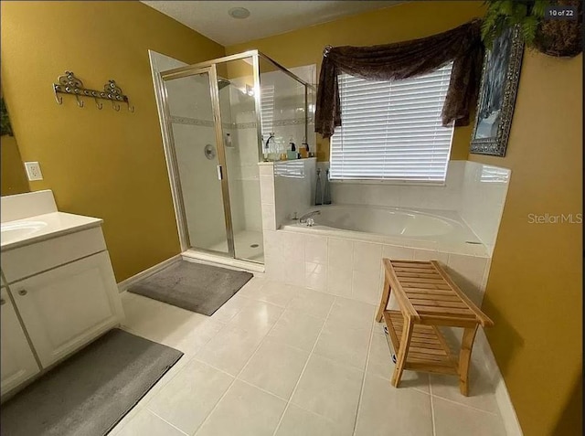 bathroom featuring a stall shower, a garden tub, vanity, and tile patterned floors