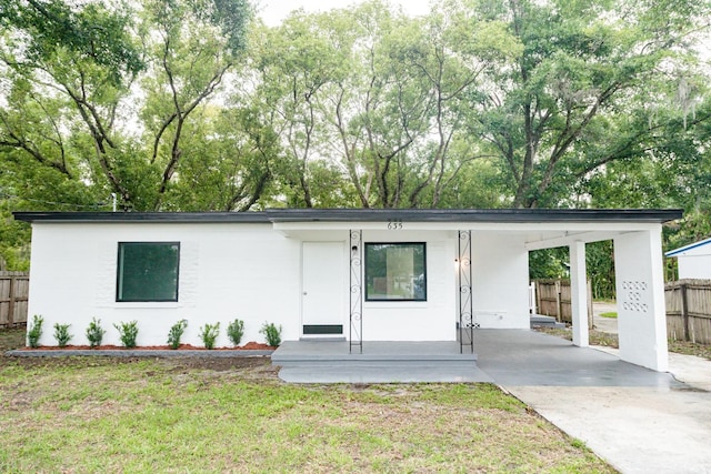 view of front of house featuring a carport and a front lawn