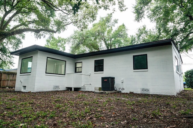 rear view of property with crawl space, cooling unit, and fence