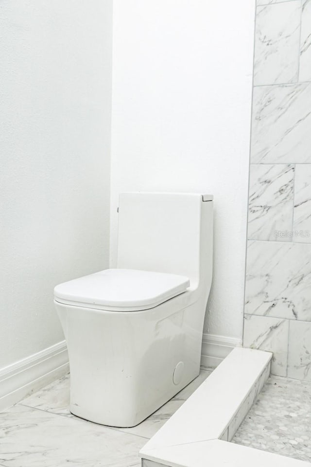 bathroom with toilet and tile patterned flooring