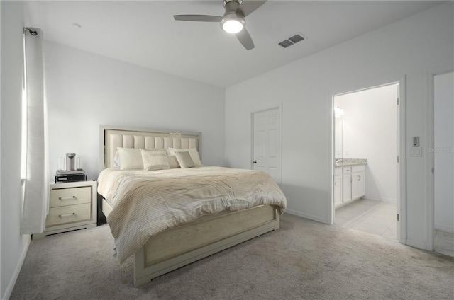 bedroom with light carpet, ensuite bath, and ceiling fan