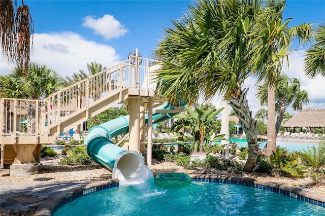 view of swimming pool with a wooden deck and a water slide