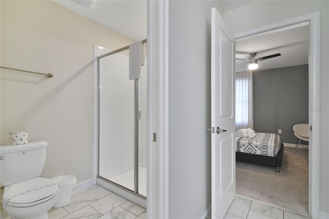 bathroom featuring ceiling fan, a shower with shower door, and toilet