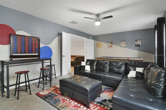 carpeted living room featuring a textured ceiling and ceiling fan