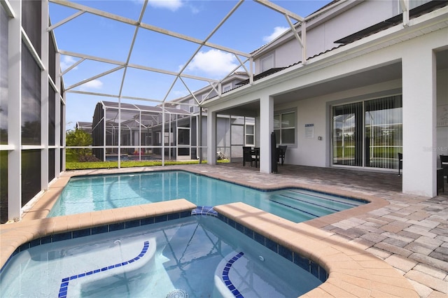 view of swimming pool featuring glass enclosure, an in ground hot tub, and a patio