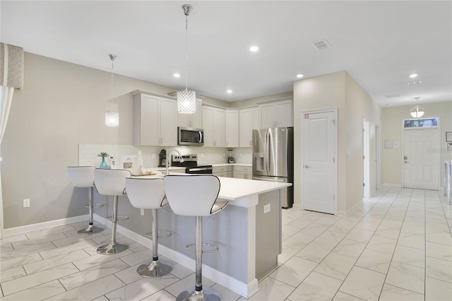 kitchen featuring decorative light fixtures, stainless steel appliances, decorative backsplash, and a breakfast bar