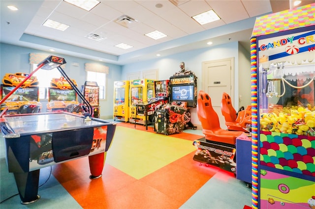 recreation room featuring a raised ceiling