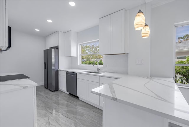 kitchen featuring stainless steel appliances, white cabinets, and pendant lighting