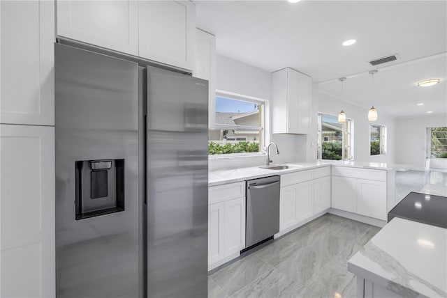 kitchen featuring stainless steel appliances, decorative light fixtures, light tile floors, sink, and white cabinets