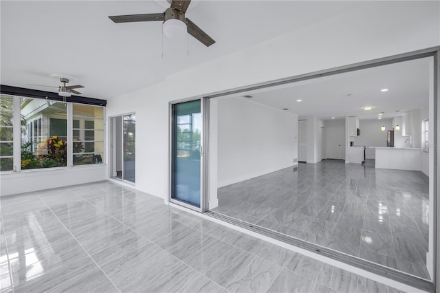 spare room featuring sink, ceiling fan, and light tile floors