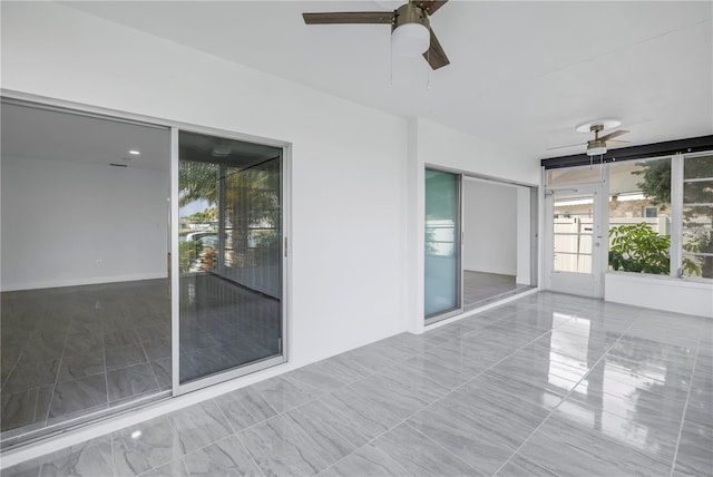 unfurnished sunroom with ceiling fan