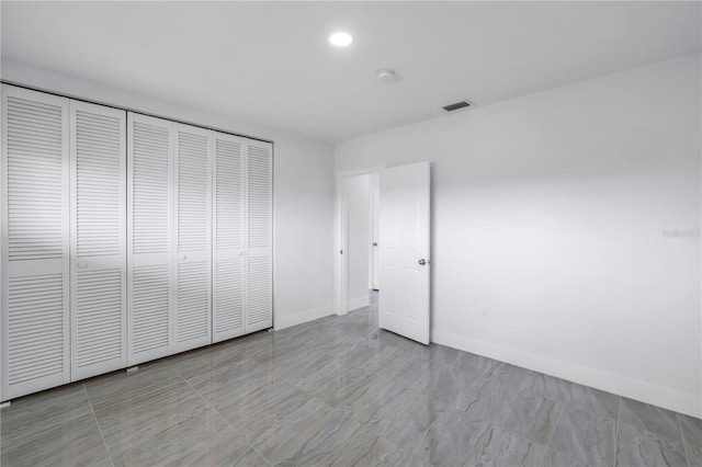 unfurnished bedroom featuring a closet and light tile flooring