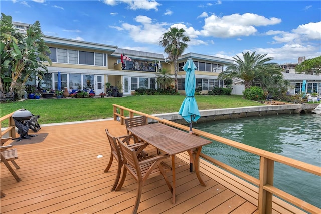 view of dock with a deck with water view and a yard