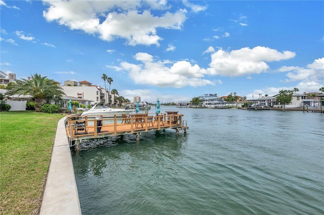 view of dock with a water view and a yard