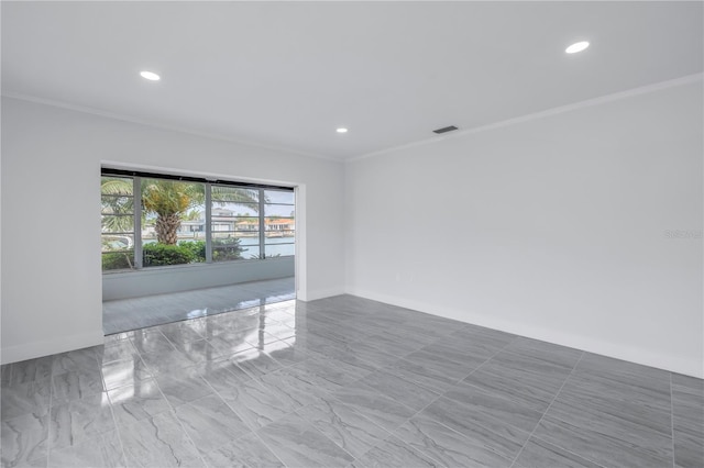 empty room featuring ornamental molding and light tile floors