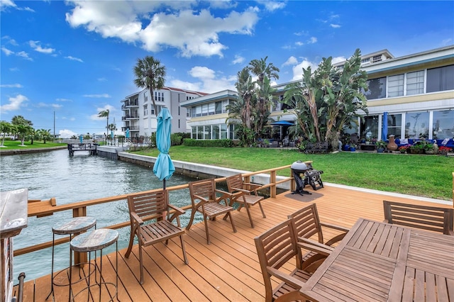 view of dock with a water view and a lawn