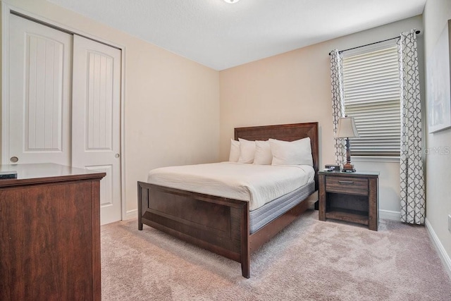 bedroom with light carpet and a closet