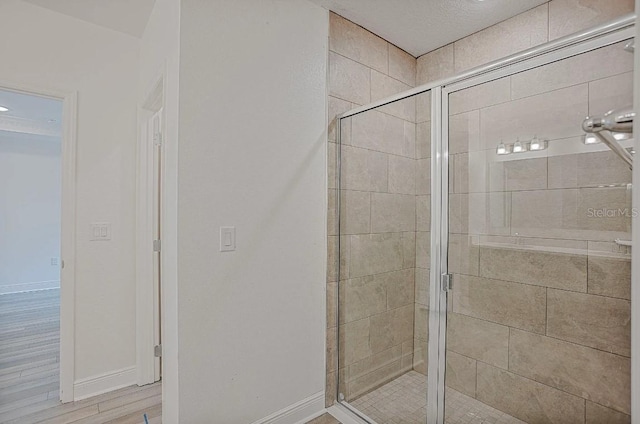 bathroom with a shower with door and hardwood / wood-style flooring