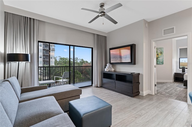 living room featuring light hardwood / wood-style flooring and ceiling fan