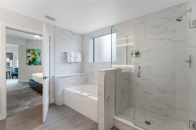 bathroom featuring wood-type flooring and separate shower and tub