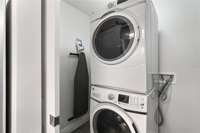 clothes washing area featuring stacked washer and dryer and a textured ceiling