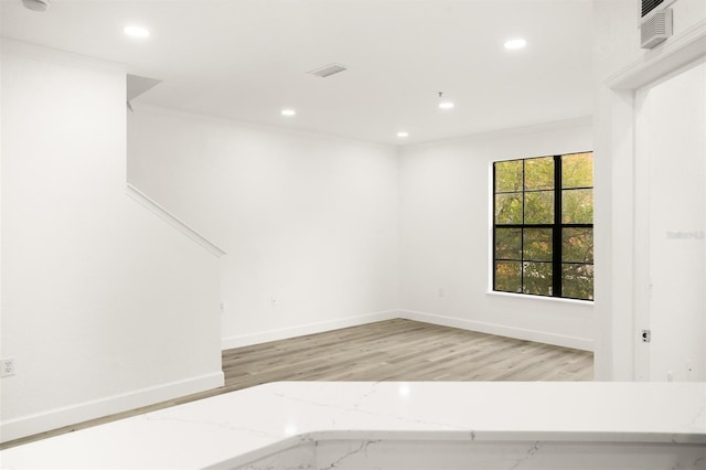 spare room featuring light hardwood / wood-style flooring and ornamental molding