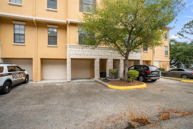 view of building exterior with cooling unit and a garage