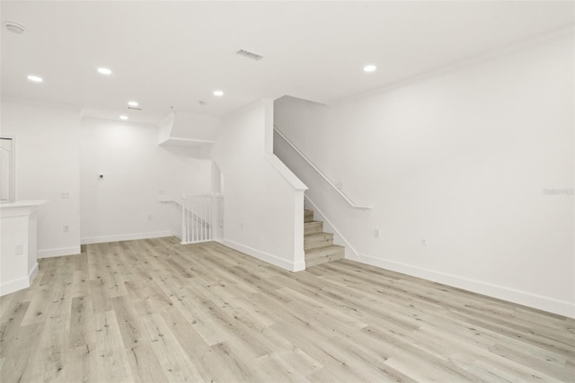 unfurnished living room with light hardwood / wood-style floors and ornamental molding