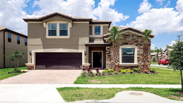 mediterranean / spanish house featuring a front yard and a garage