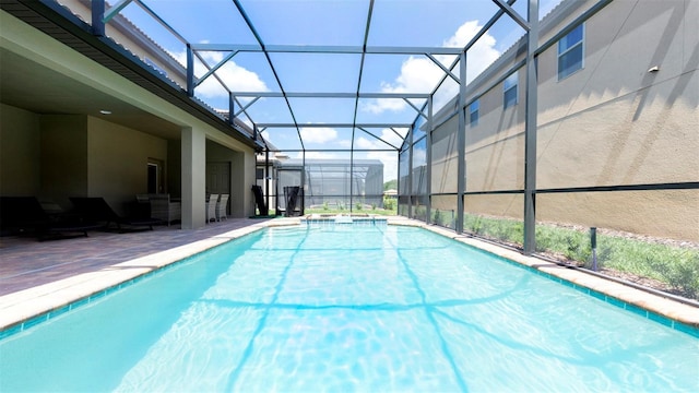 view of pool featuring glass enclosure, a patio area, and a hot tub