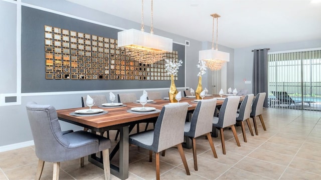 dining space featuring tile patterned floors and an inviting chandelier