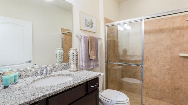 bathroom with vanity, toilet, and a shower with shower door